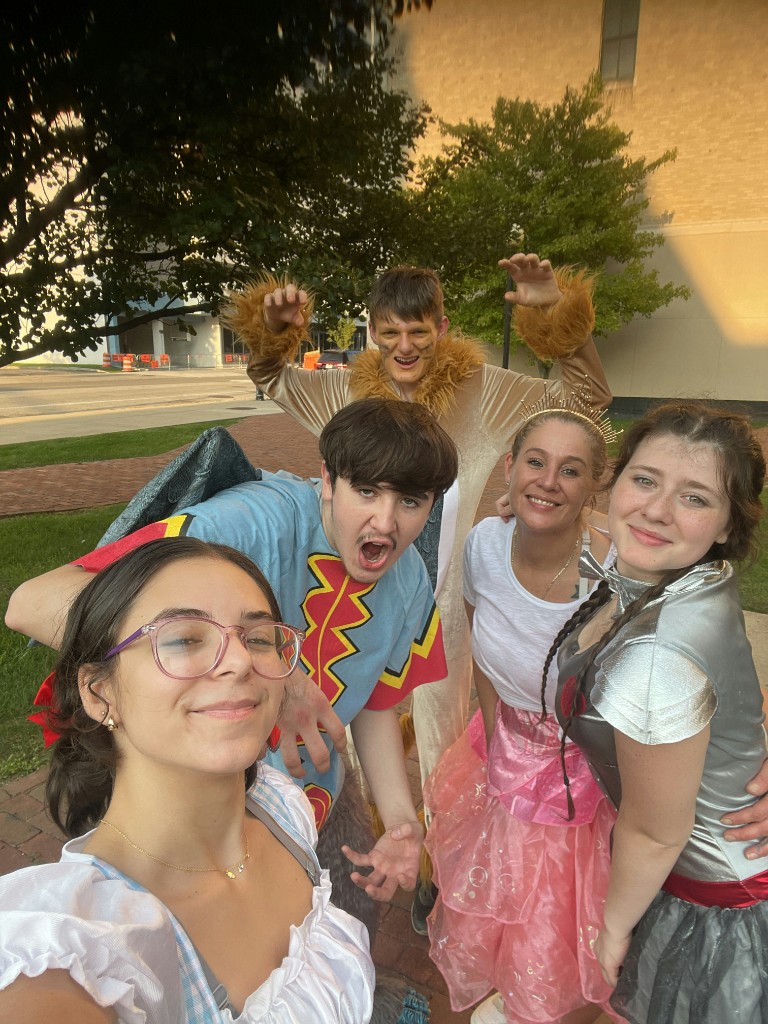 Young friends taking a group selfie in Oz costumes including Dorothy and Cowardly Lion